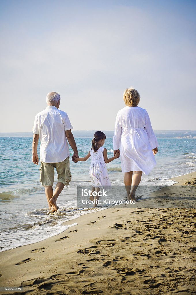 Menina e sua avós caminhando na praia - Foto de stock de Criança royalty-free