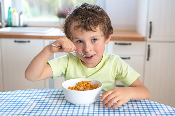 istock portrait of small boy eating corn flakes 174926890