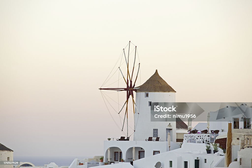 Wiatrak na wschód słońca w Oia Village. Santorini. Grecja. - Zbiór zdjęć royalty-free (Architektura)