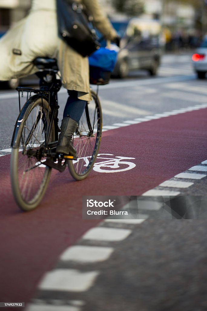 Donna in bicicletta in traffico - Foto stock royalty-free di Ciclismo