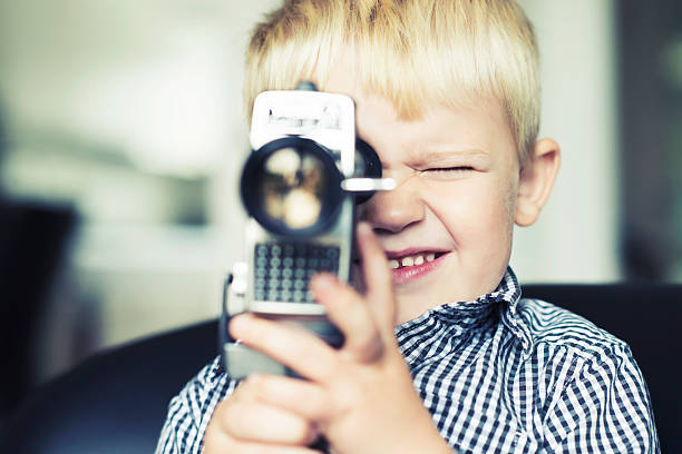 Boy shootsing a video with an old retro cine camera