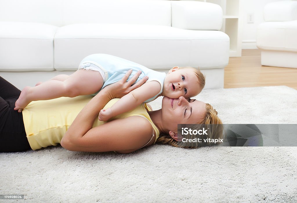 Madre y bebé jugando en la sala de estar de la suite white - Foto de stock de Moqueta libre de derechos