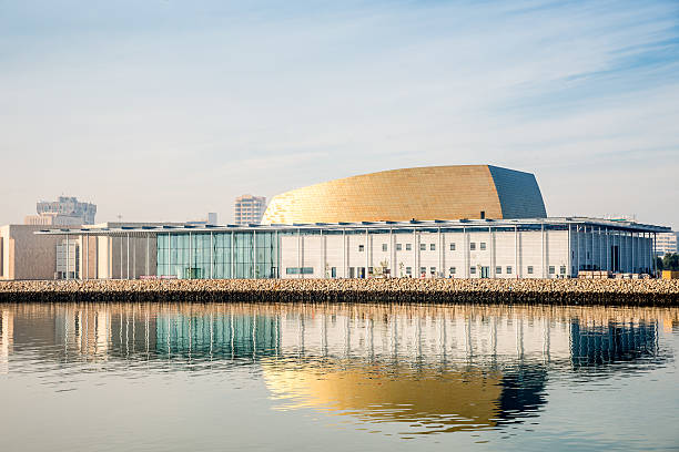 National Theater of  Bahrain, Manama "Golden roof of the modern National Theater of Bahrain Building mirroring in the water. City of Manama, Kingdom of Bahrain, Middle East." manama stock pictures, royalty-free photos & images