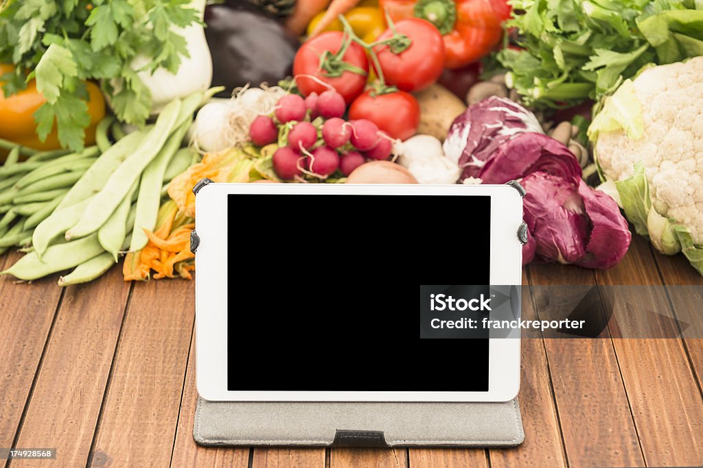 Mezcla orgánica verduras crudas en la mesa con tableta digital - Foto de stock de Achicoria roja libre de derechos