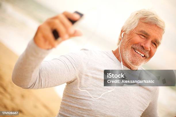Senior Hombre Usando Un Teléfono Inteligente Foto de stock y más banco de imágenes de Auriculares - Equipo de música - Auriculares - Equipo de música, Bailar, 60-69 años