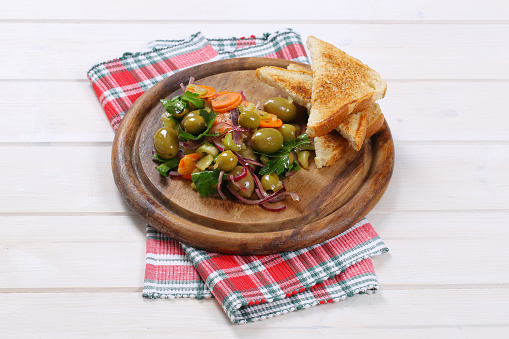 Sicilian olive salad and toasted bread on cutting board