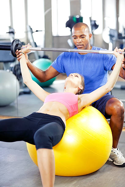 istock woman practicing  upper body muscle group with personal trainer 174928767