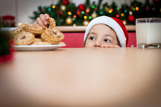 Cookie Thief Little Girl peeking over counter and sneaking a cookie tiptoe stock pictures, royalty-free photos & images