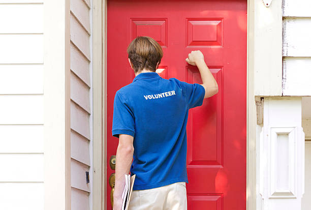 Teenage Volunteer Petitioning or Canvassing "Teenage volunteer canvassing, knocking on doors.&nbsp;More canvassing, polling, and volunteer files" knocking on door stock pictures, royalty-free photos & images