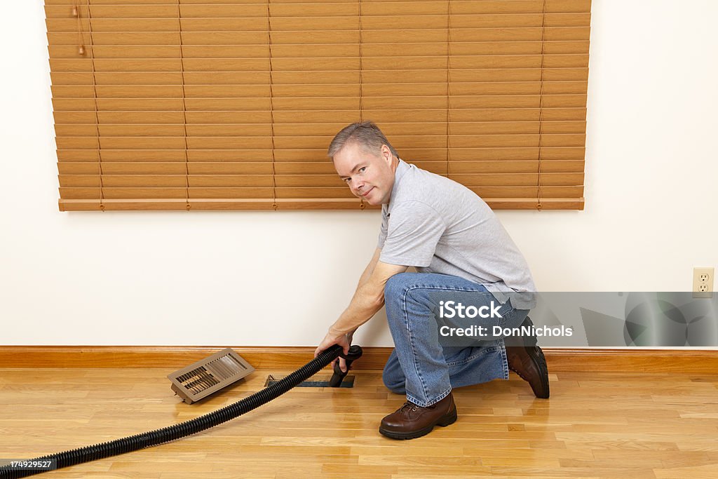 Un operaio pulizia del condotto di ventilazione - Foto stock royalty-free di Adulto