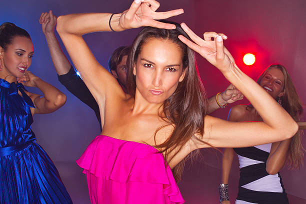 istock Woman Gesturing Peace Sign While Dancing At Nightclub 174929717