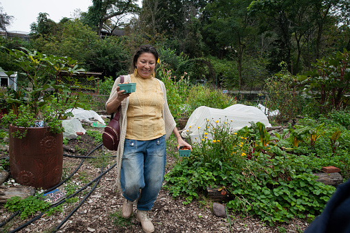 Single Mom carrying cherry tomatoes in community garden