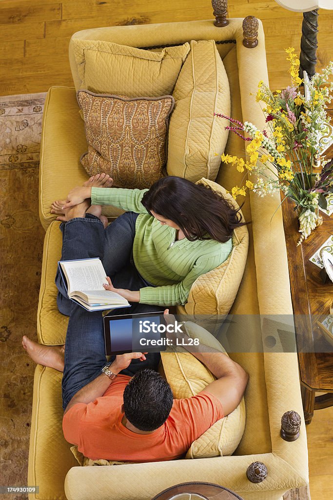 Casal com Tablet Digital e Reserve no sofá - Foto de stock de 30 Anos royalty-free