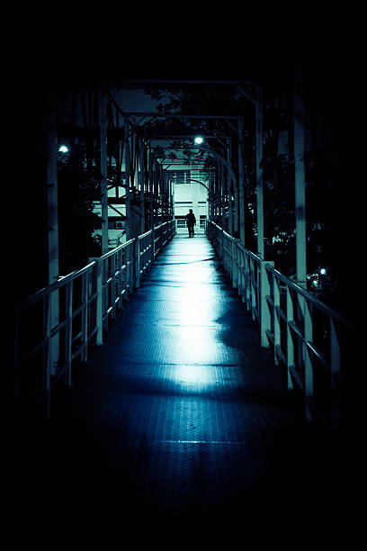 Man alone in a connection bridge at night
