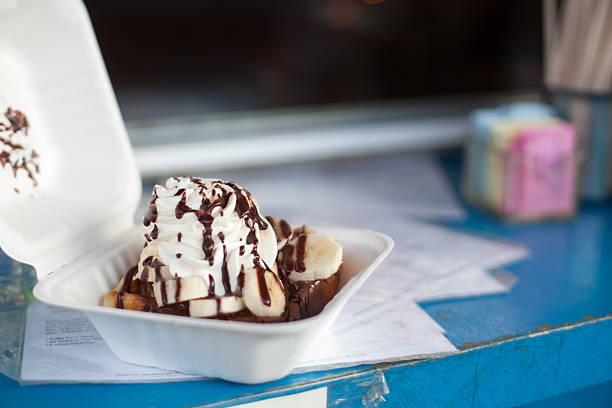 Waffle with nutella, bananas and whipped cream in to-go box stock photo