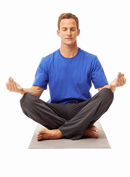 Full length body size photo smiling man in blue shirt sitting on floor practising yoga isolated pastel pink color background