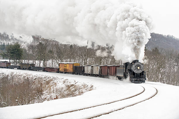 istock Steam Locomotive Pulling Freight Train in Winter Snow, Mountain Railroading 174931238