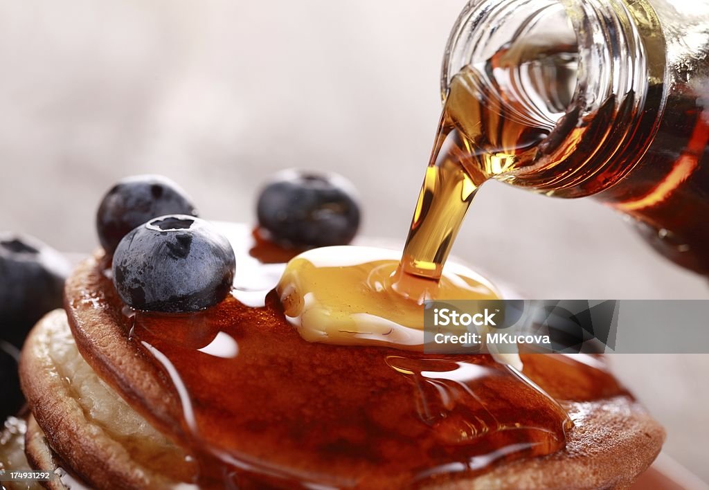 Pouring syrup Close-up of pouring maple syrup on stack of pancakes. Maple Syrup Stock Photo
