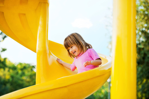 Cute girl having fun on slide.