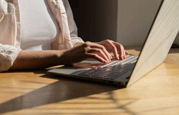 istock Freelance worker working at laptop computer on wood table, desk, sunny day, sunlight and shadow 1749318710