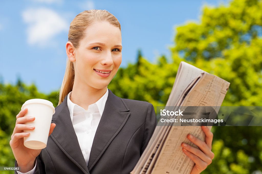 Mujer sosteniendo ejecutiva, periódico y taza desechable - Foto de stock de 20 a 29 años libre de derechos