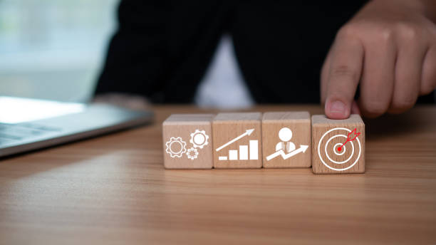 istock A businessman points to a dart board printed on square wooden blocks representing setting business goals. 1749331340