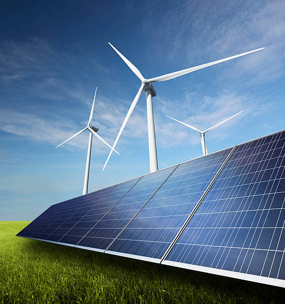 istock Wind turbines and solar panels on green grass with blue sky 174933435