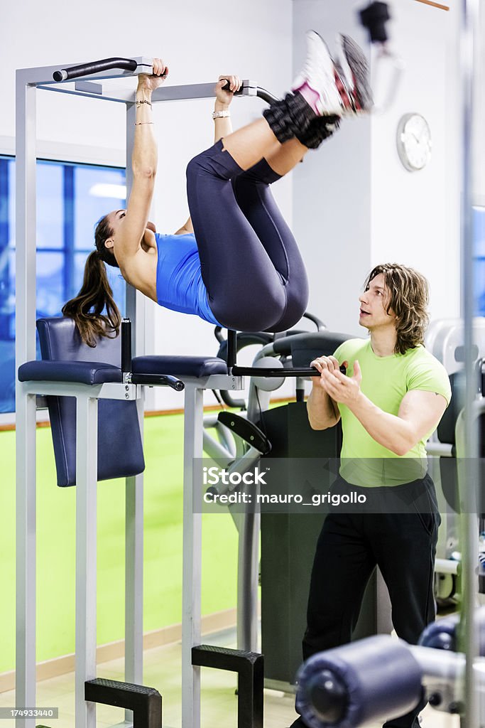 Donna facendo crunch esercizi con personal trainer - Foto stock royalty-free di Abbigliamento casual