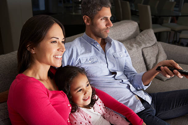 istock Family sitting on sofa watching TV 174933567