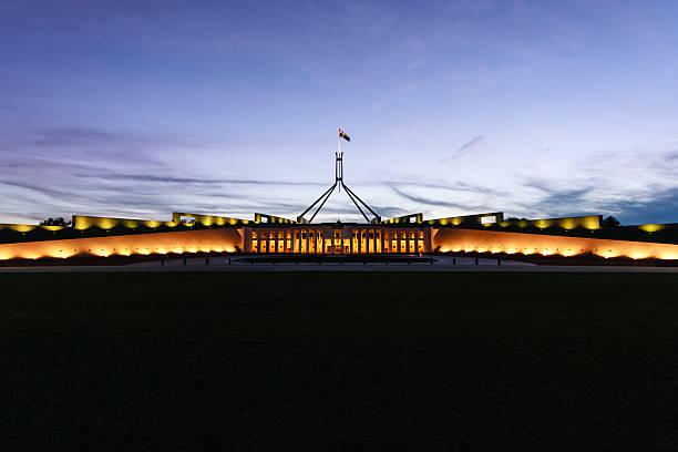 Australian Parliament House illuminated with dark blue sky Australian Parliament House in the evening. canberra photos stock pictures, royalty-free photos & images