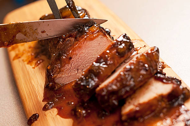 Slicing a barbecue pork tenderloin stock photo