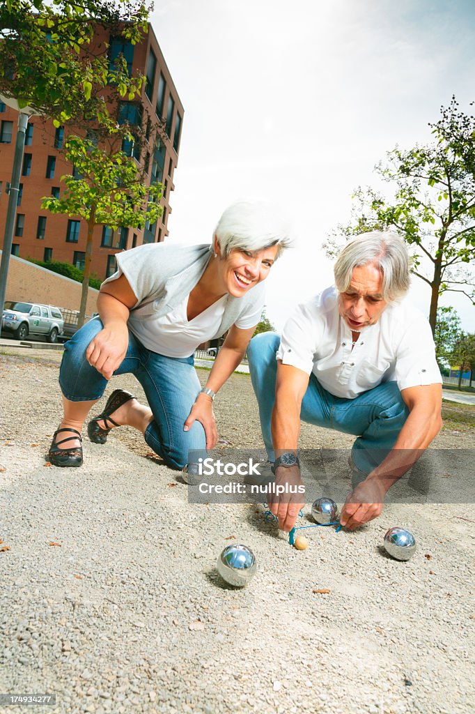 senior couple playing a game of boule Boules Stock Photo