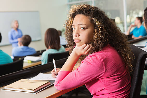 istock Bored high school or college student looking back in class 174934551