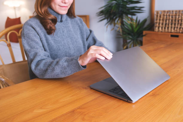 istock Closeup image of a woman closing or opening a laptop computer on table after finished using it 1749347609