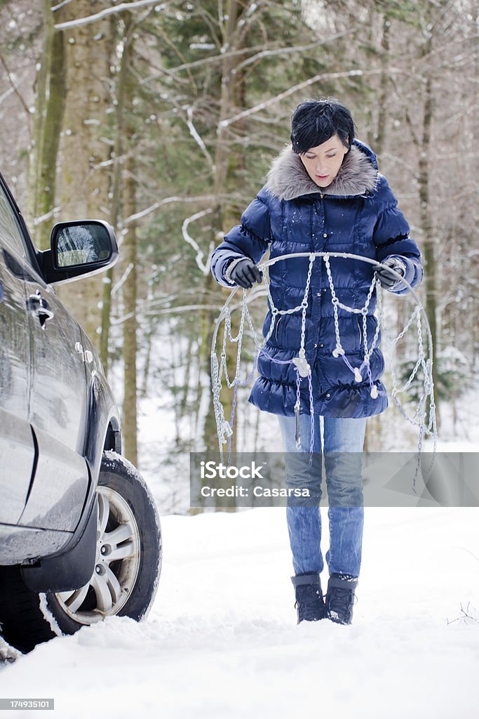 Mulher instalar Correntes para neve - Foto de stock de Adulto royalty-free