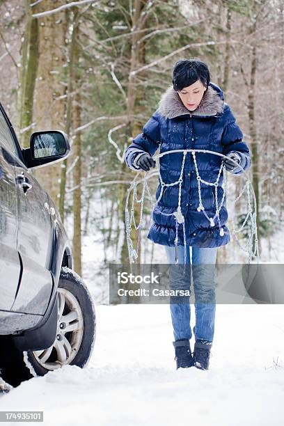 Foto de Mulher Instalar Correntes Para Neve e mais fotos de stock de Adulto - Adulto, Assistência, Beleza