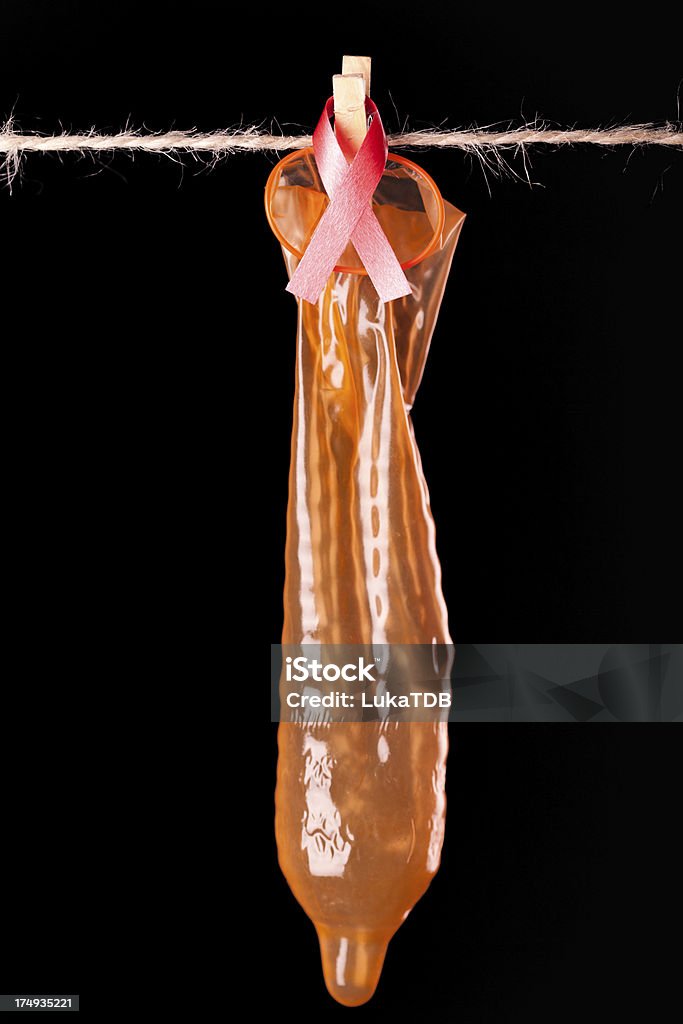 Оранжевый презерватив и справочные красной лентой со СПИДом - Стоковые фото Без людей роялти-фри