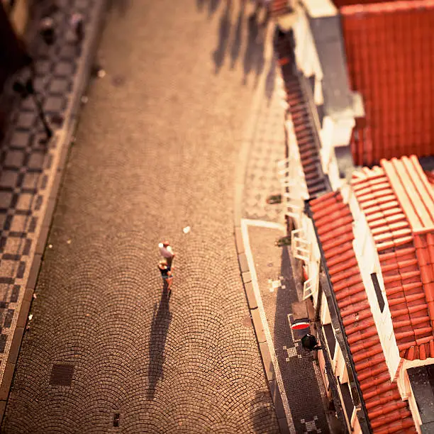 Aerial view of people on a cobblestone alley in Prague at sunset. Tilt shift lens.More images from Prague: