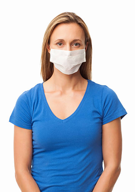 Two surgical masks making a cross to symbolise the first aid symbol as well as the Swiss flag. This is a conceptual image illustrating the concept of medical help during the pandemic of Covid-19 (Coronavirus) and other medical emergencies.