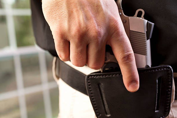 istock Close up  man drawing weapon gun pistol from leather holster 174936039
