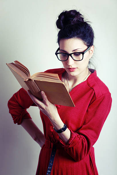 istock Student in vintage nerdy glasses reading a book 174936512