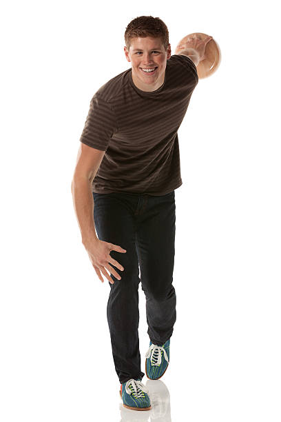 souriant jeune homme jouant avec une boule de bowling - bowling isolated sportsman vertical photos et images de collection