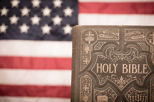 antica sacra bibbia, ornato con bandiera americana backgroun - bible american flag flag old fashioned foto e immagini stock