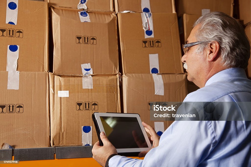 Cargo homme vérifiant sur Tablette numérique - Photo de Entrepôt de distribution libre de droits