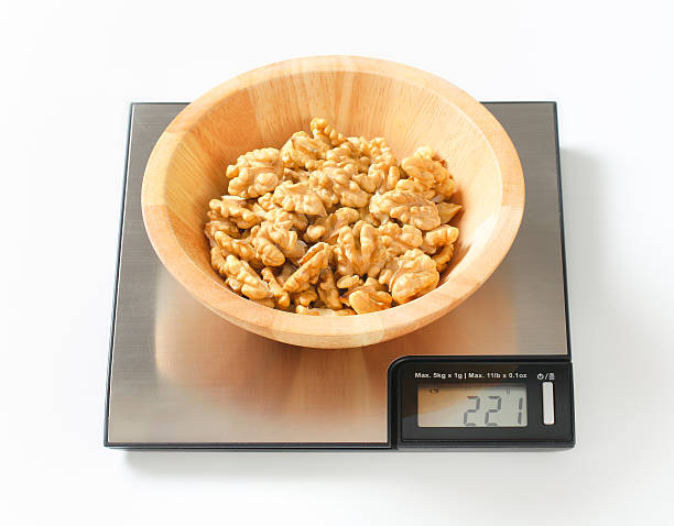istock bowl of walnuts on a digital scale 174938312