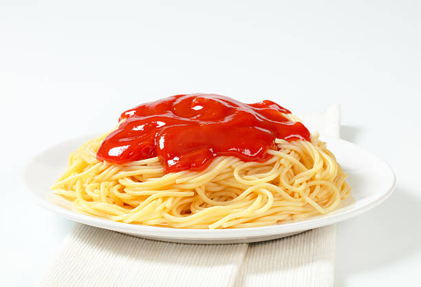 plate of freshly boiled spaghetti with a tomato sauce on a white folded placemat