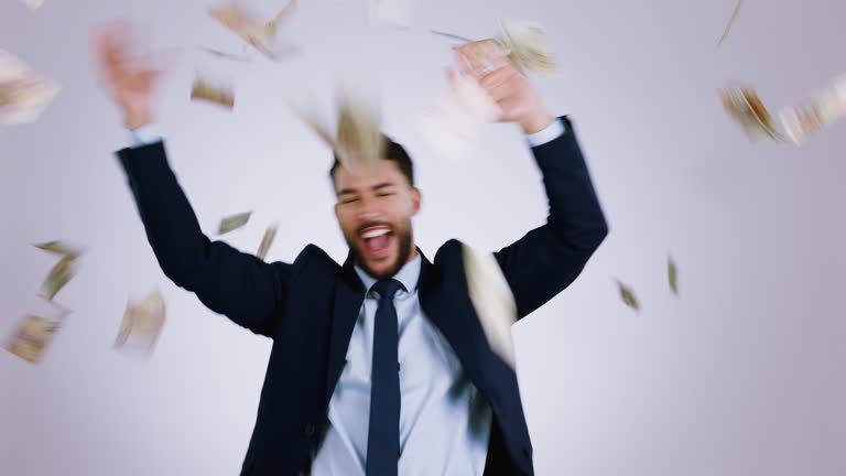 Excited, money rain and business man in studio for payment bonus, competition and lottery winner. Dance, finance and worker on white background with cash confetti for profit, success and investment