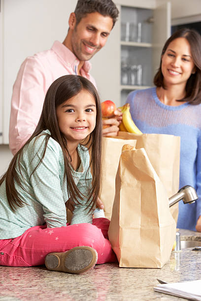 istock Family Unpacking Grocery Shopping In Kitchen 174939205