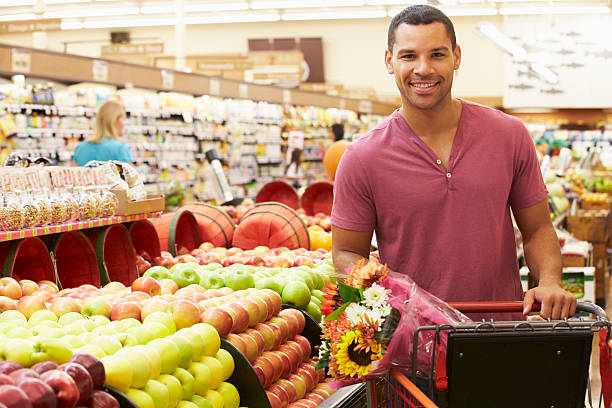 istock Man Pushing Trolley By Fruit Counter In Supermarket 174939401