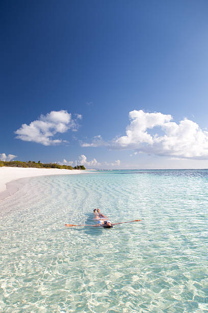 istock bikini woman floating in water at a Caribbean beach 174939681